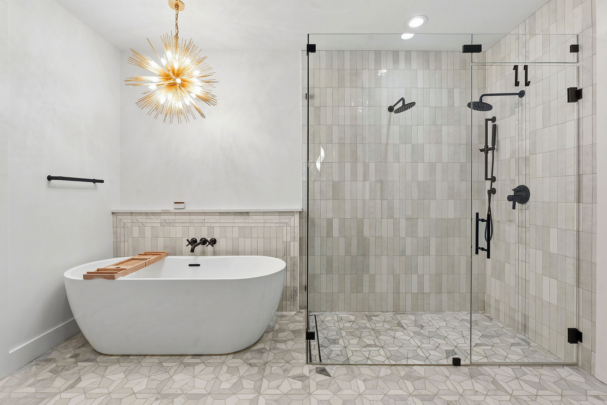 2004 Riverview Street Austin, TX 78702 - Photo 24 of 36 Freestanding soaking tub with a modern chandelier overhead, alongside a glass-enclosed shower featuring a rain showerhead and body sprayers