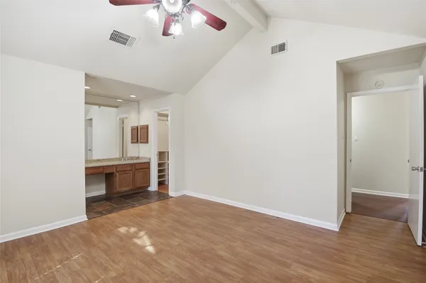 a view of room and a ceiling fan wooden floor and windows