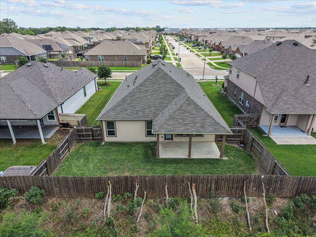 2320 Rosemary Street Rosenberg, TX 77469 - Photo 4 of 40 This aerial view showcases a suburban home with a fenced backyard, covered patio, and well-maintained lawn. It's situated in a neighborhood with similar houses and neatly arranged streets.