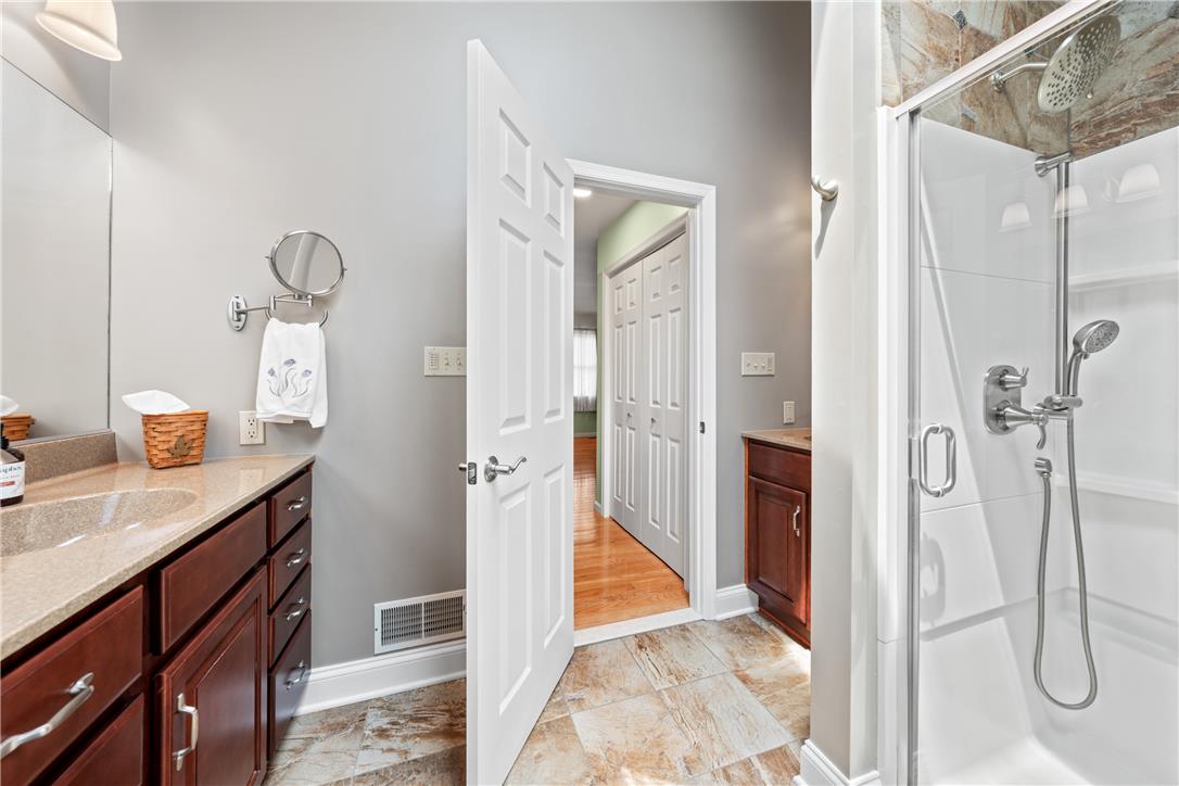 4568 Greenfield Road Bethlehem, PA 18017 - Photo 26 of 59 A well-appointed bathroom with dual vanities and a glass-enclosed shower stall.