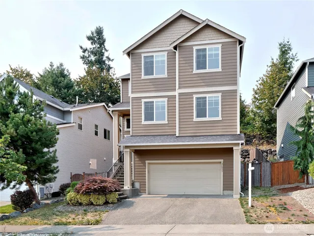 a front view of a house with a yard and garage
