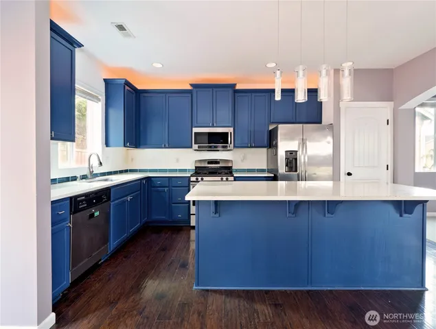 a kitchen with stainless steel appliances wooden cabinets a sink and a stove