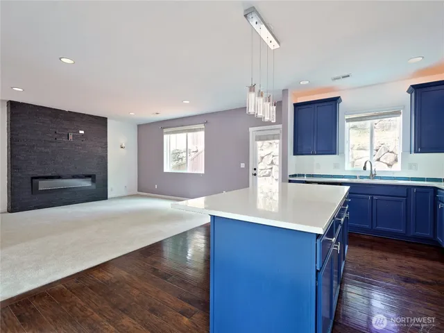 a kitchen with kitchen island a sink appliances and a counter top space