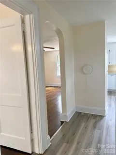 an empty room with wooden floor and entrance