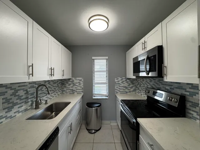 a kitchen with a sink stove and microwave