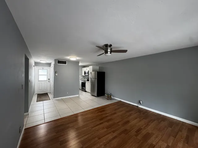 a view of a livingroom with wooden floor and a ceiling fan