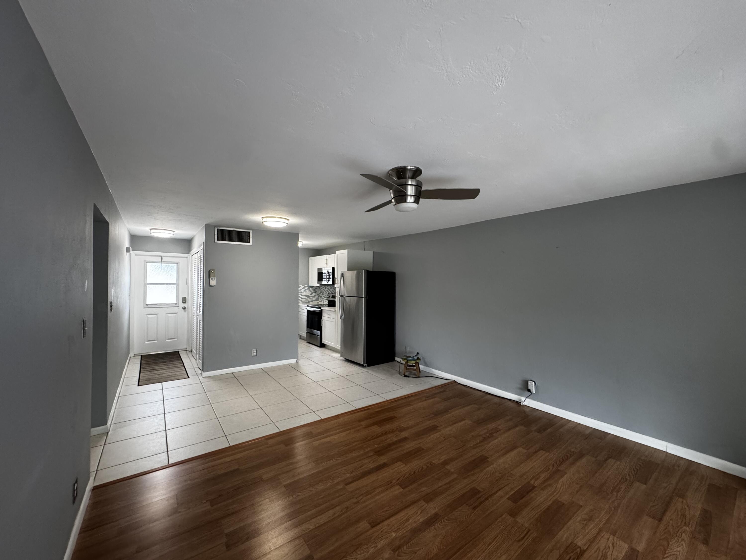 73 East Court, Unit 73 Royal Palm Beach, FL 33411 - Photo 3 of 17 a view of a livingroom with wooden floor and a ceiling fan