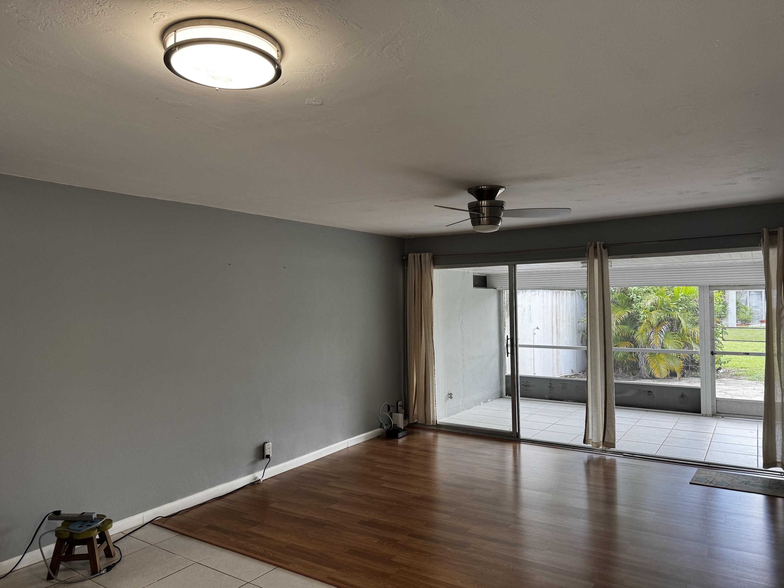 73 East Court, Unit 73 Royal Palm Beach, FL 33411 - Photo 6 of 17 an empty room with wooden floor and windows