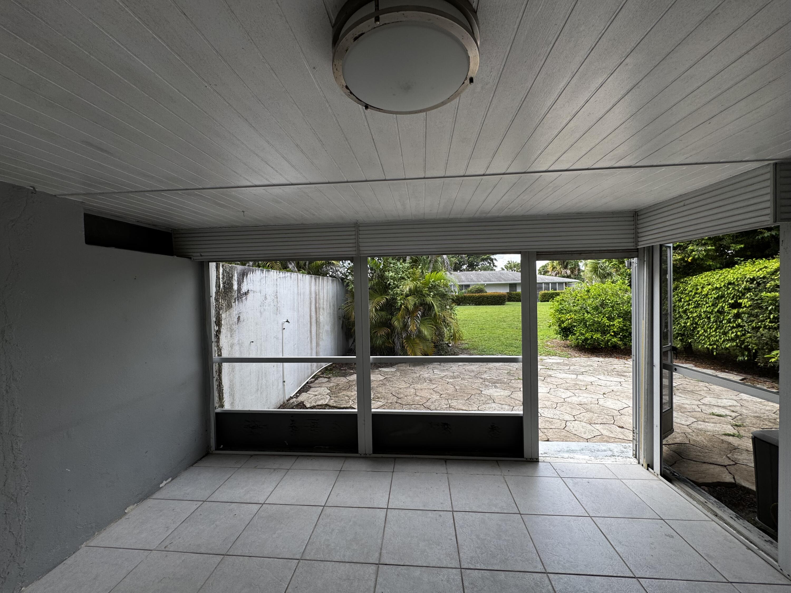 73 East Court, Unit 73 Royal Palm Beach, FL 33411 - Photo 7 of 17 a view of an empty room with a fireplace and a large window