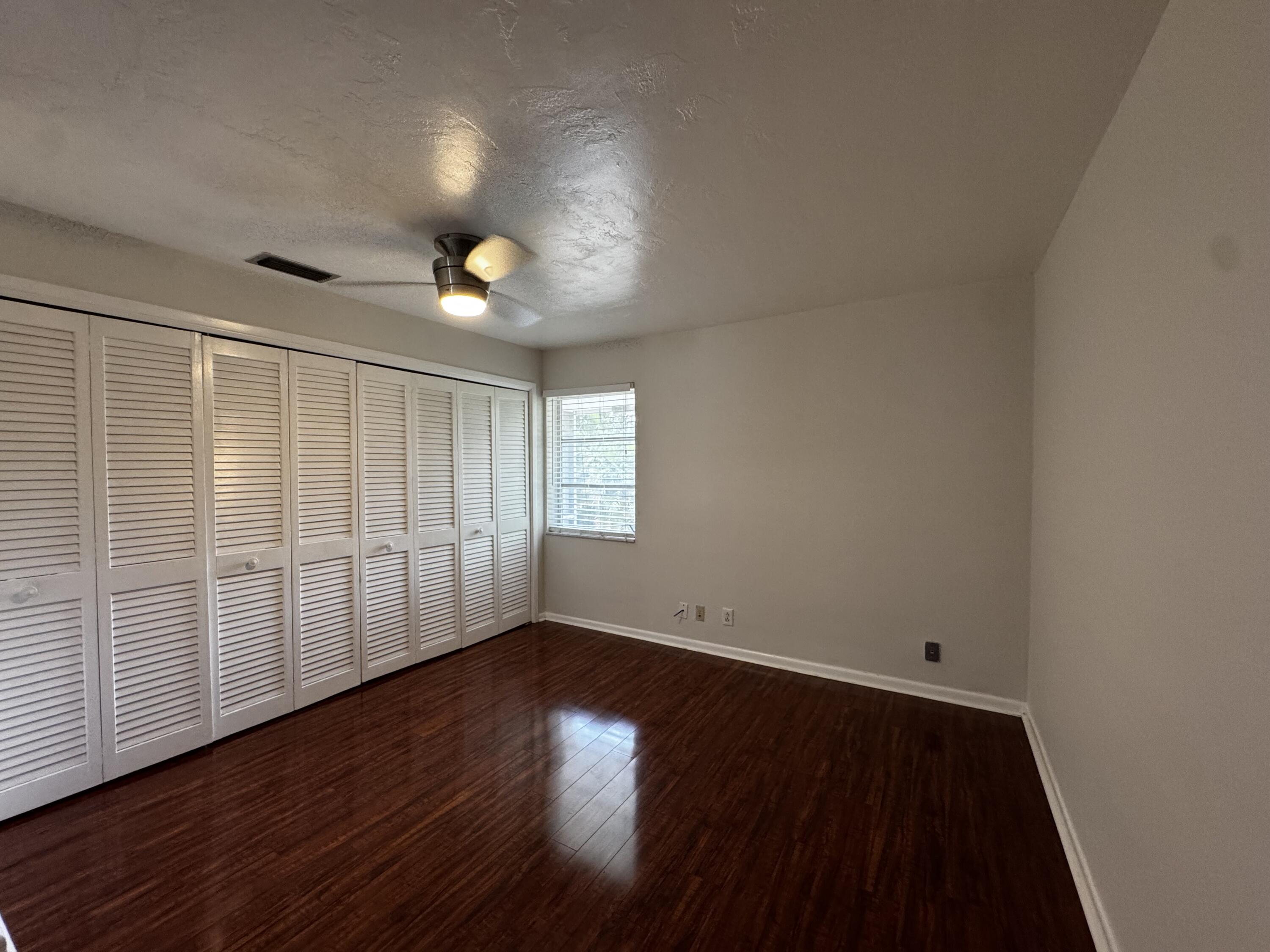 73 East Court, Unit 73 Royal Palm Beach, FL 33411 - Photo 10 of 17 wooden floor in an empty room with a window
