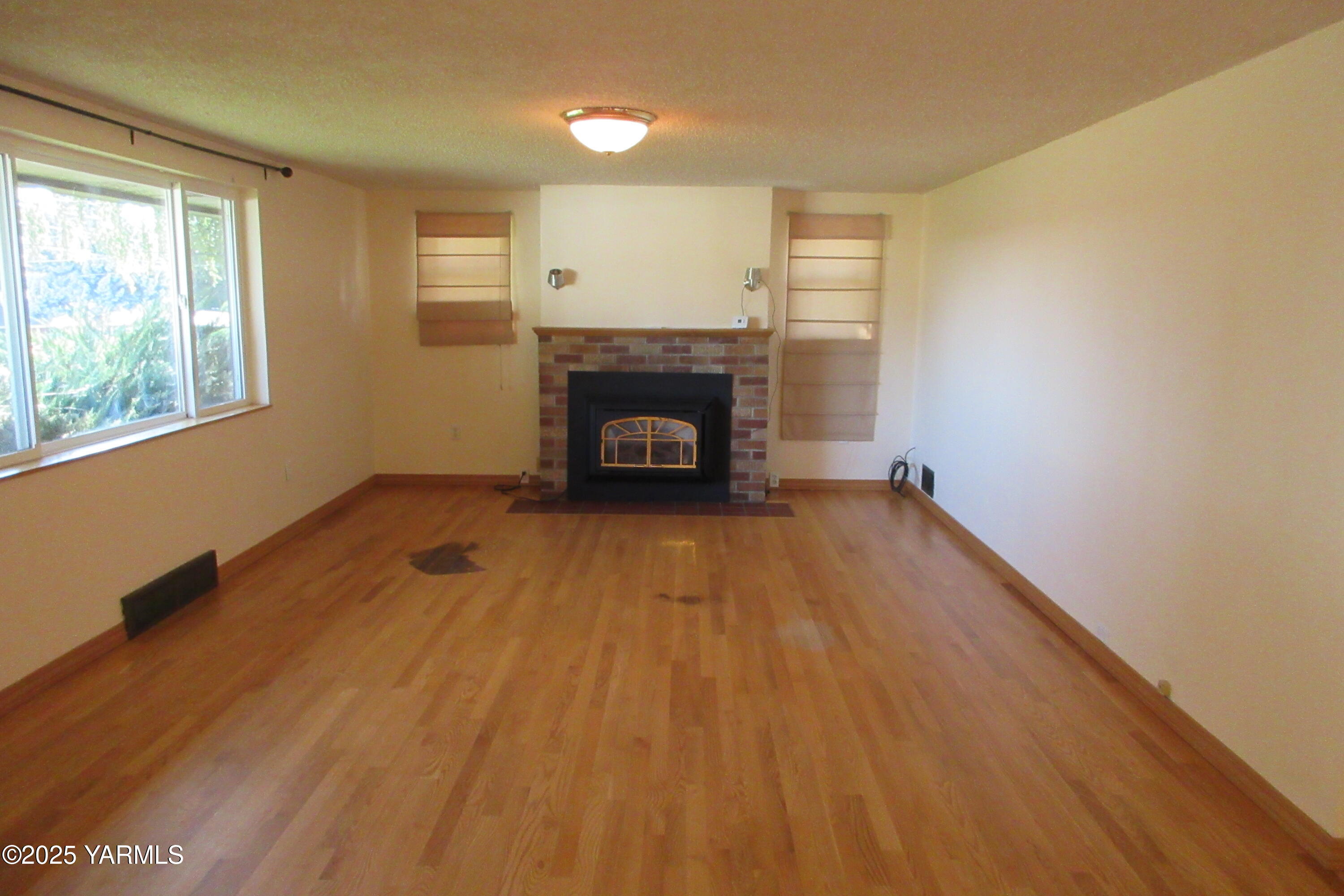2703 Cascade Road Yakima, WA 98901 - Photo 15 of 24 a view of an empty room with a fireplace and a window