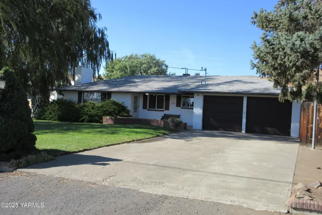a front view of a house with a yard and potted plants