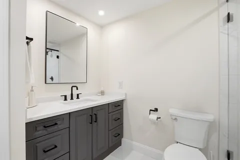 a bathroom with a toilet sink and mirror
