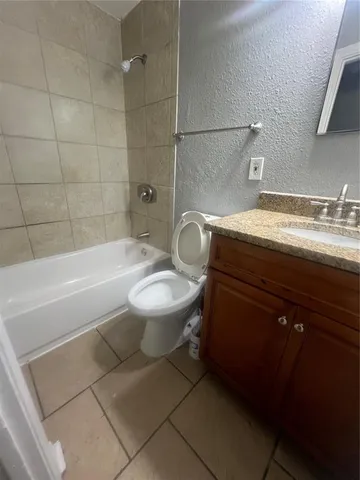 a bathroom with a granite countertop toilet a sink and bathtub