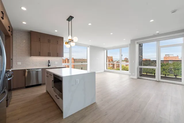 a kitchen with stainless steel appliances granite countertop a sink stove and wooden floor
