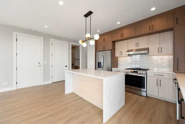 a kitchen with kitchen island white cabinets and stainless steel appliances