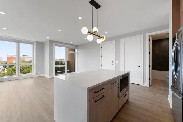 a kitchen with a stove a window and wooden floors