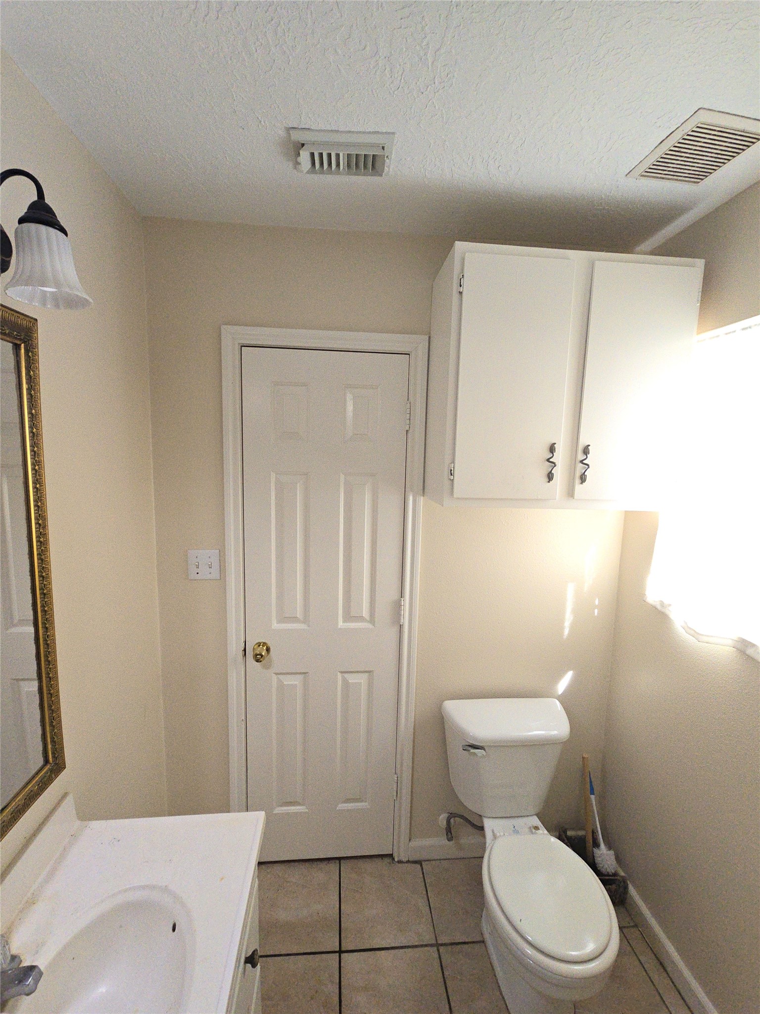 409 Commerce Street Tomball, TX 77375 - Photo 12 of 25 a white toilet sitting next to a bathroom sink and tub