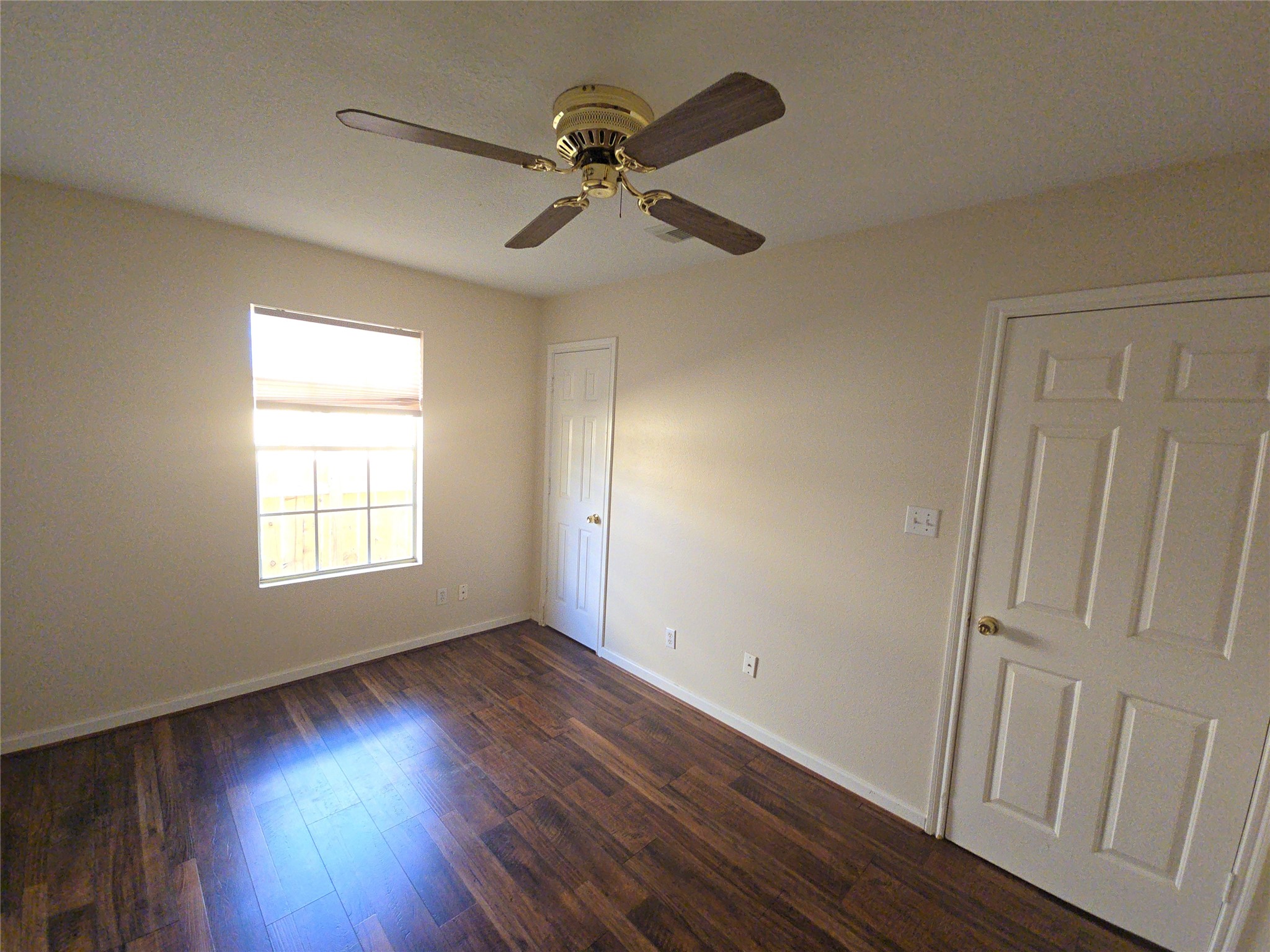 409 Commerce Street Tomball, TX 77375 - Photo 13 of 25 an empty room with wooden floor fan and windows