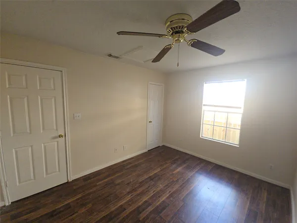 a view of empty room with wooden floor