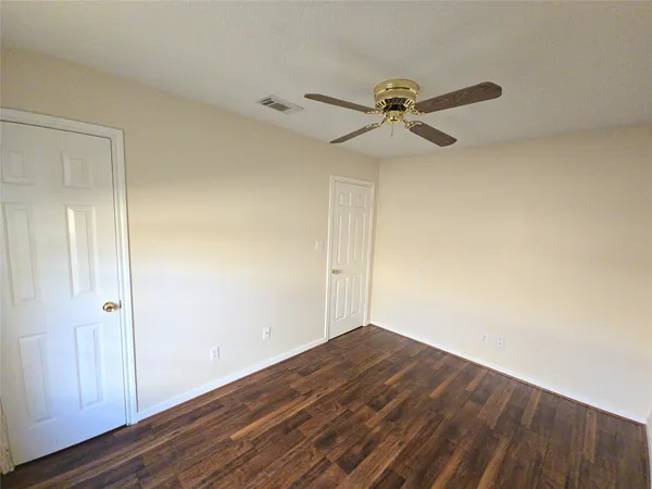a view of a room with wooden floor and fan