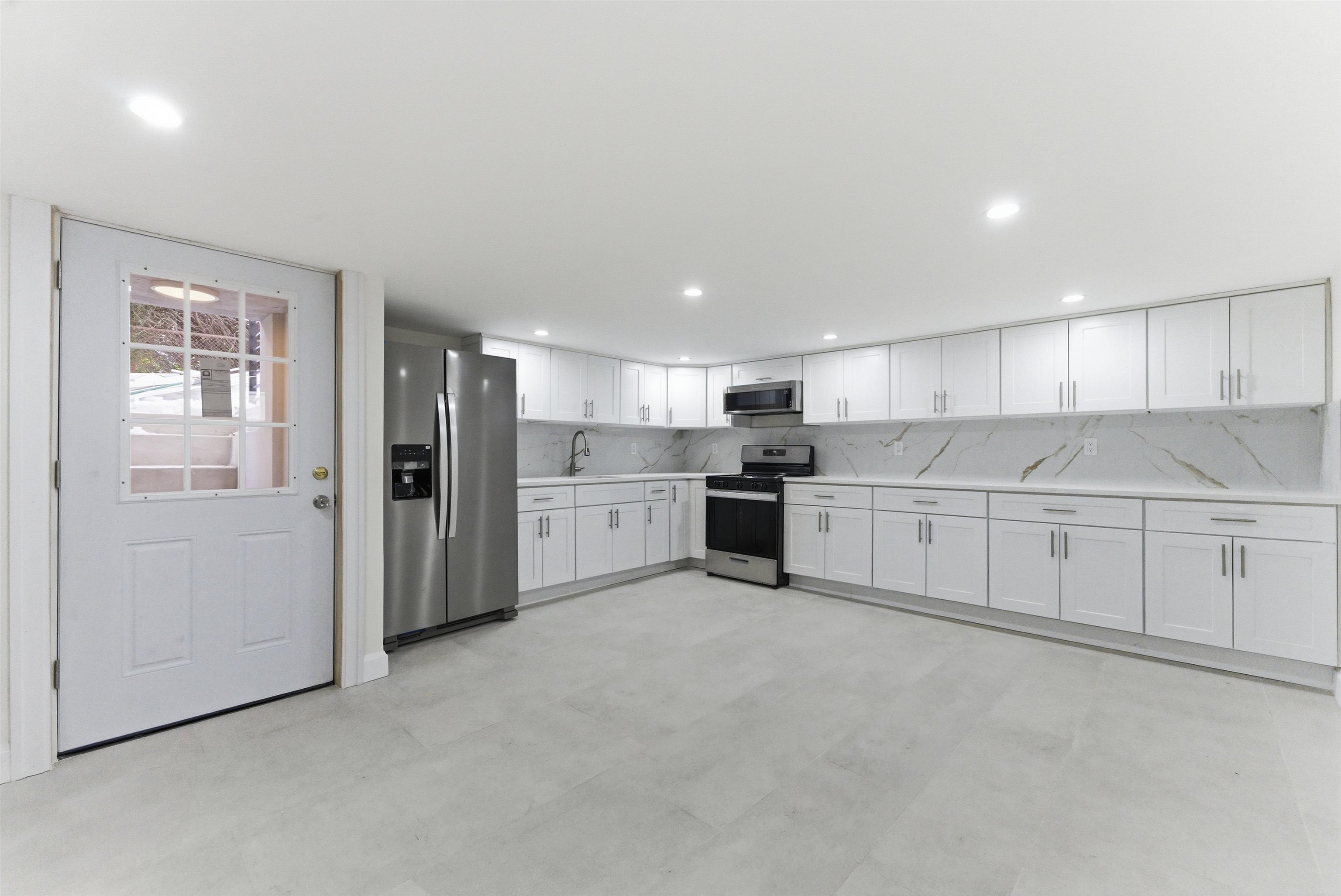 703 3rd Street Secaucus, NJ 07094 - Photo 35 of 49 a kitchen with stainless steel appliances granite countertop a refrigerator sink and white cabinets