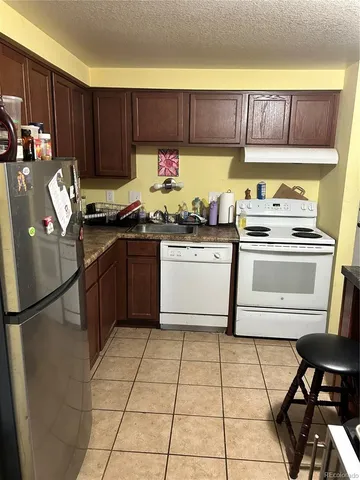 a kitchen with a refrigerator sink and cabinets