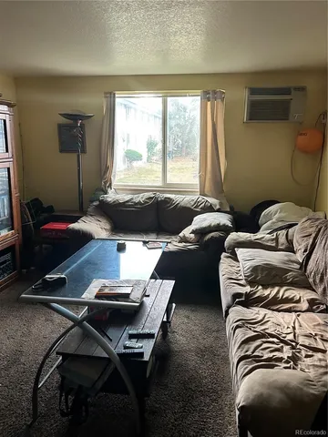 a living room with furniture a flat screen tv and a window