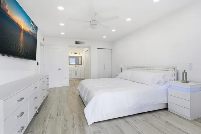 a spacious bedroom with a bed and a flat screen tv