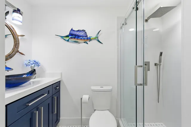 a bathroom with a sink vanity mirror and toilet