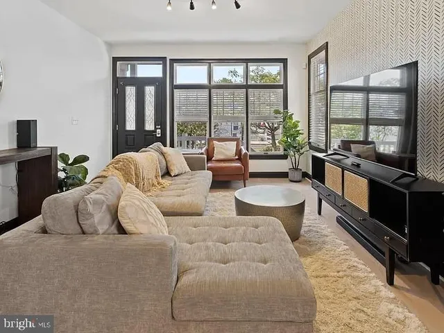 a living room with furniture and large windows