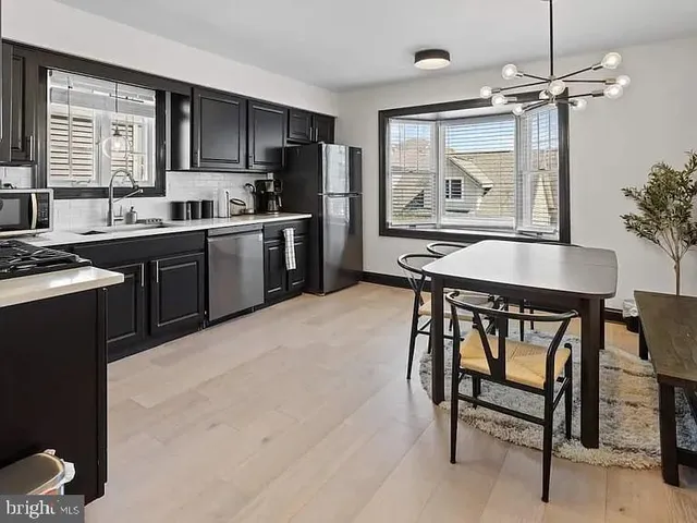 a kitchen with granite countertop a stove a sink and a refrigerator