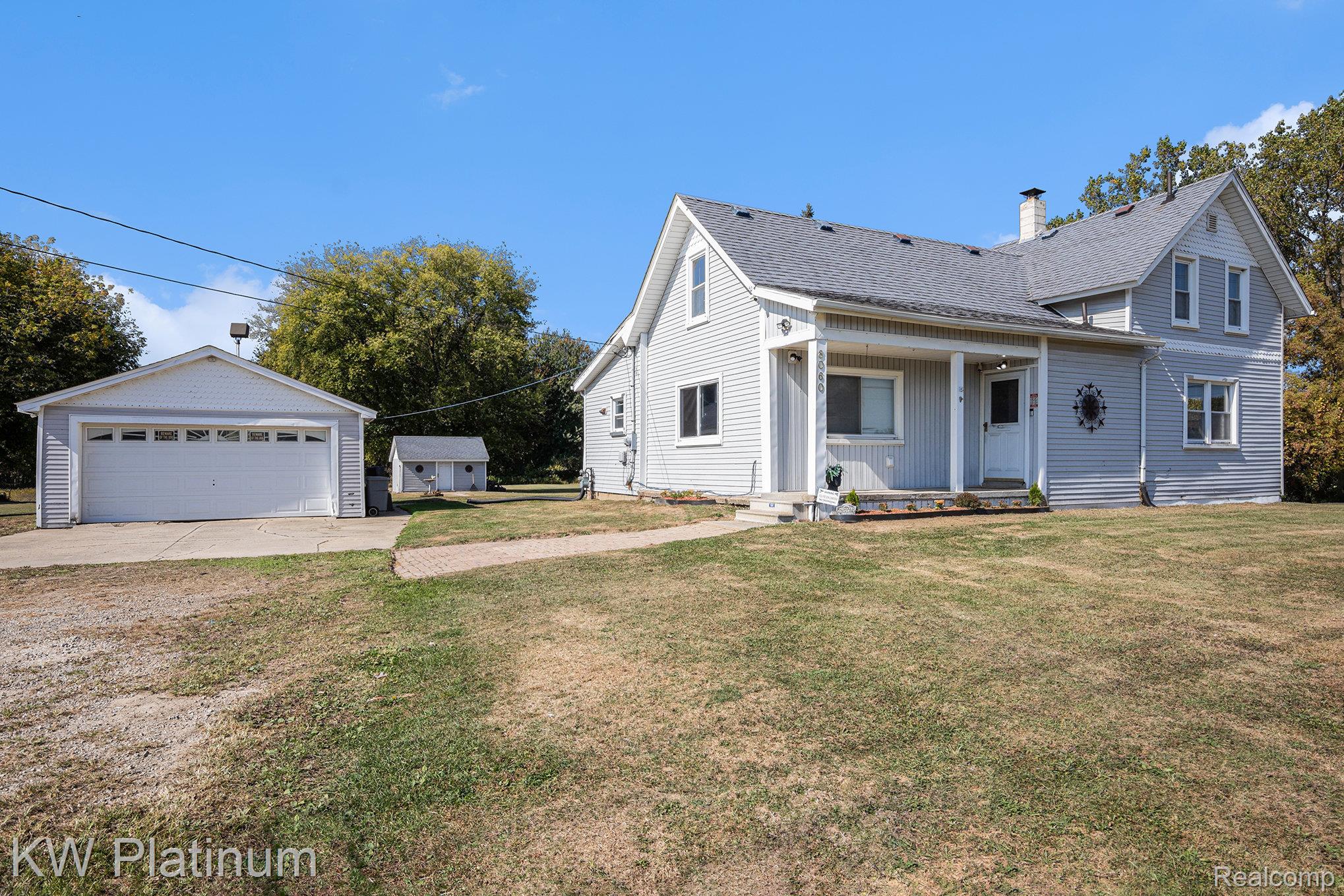 8060 Brockway Road Melvin, MI 48454 - Photo 1 of 39 View of front of home featuring an outbuilding, a front yard, a garage, and a chimney