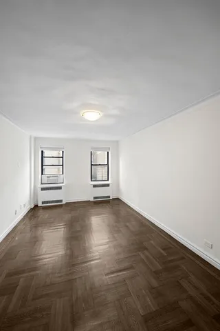 an empty room with windows and closet