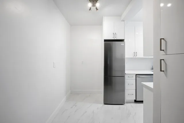 a kitchen with a refrigerator and cabinets