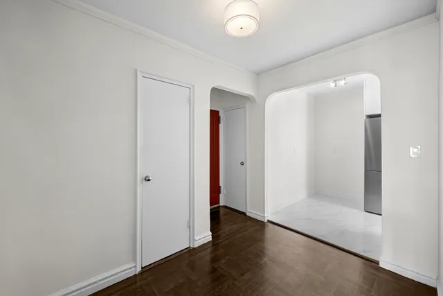 an empty room with wooden floor and closet