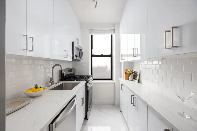 a kitchen with a sink a refrigerator and cabinets