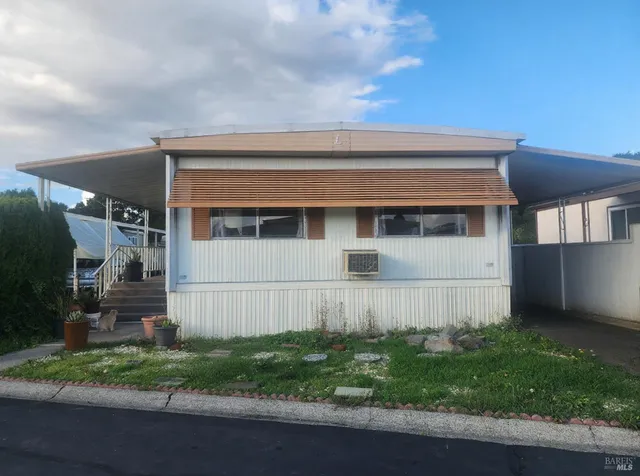 a view of house with backyard and parking