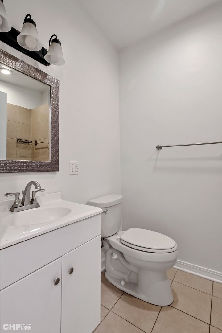 1052 North Springfield Avenue Chicago, IL 60651 - Photo 14 of 31 a bathroom with a toilet sink and mirror