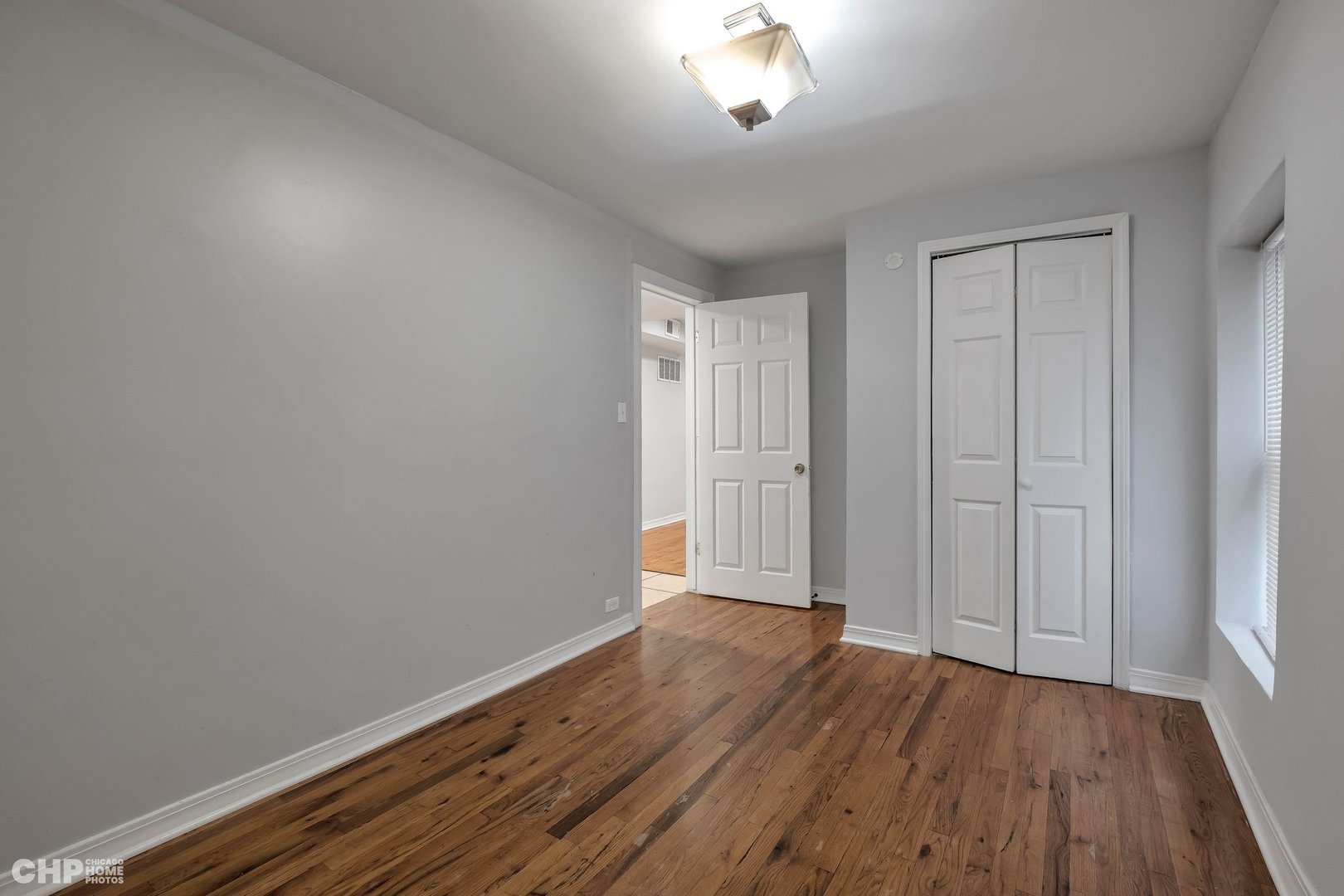 1052 North Springfield Avenue Chicago, IL 60651 - Photo 23 of 31 a view of an empty room with wooden floor and a window