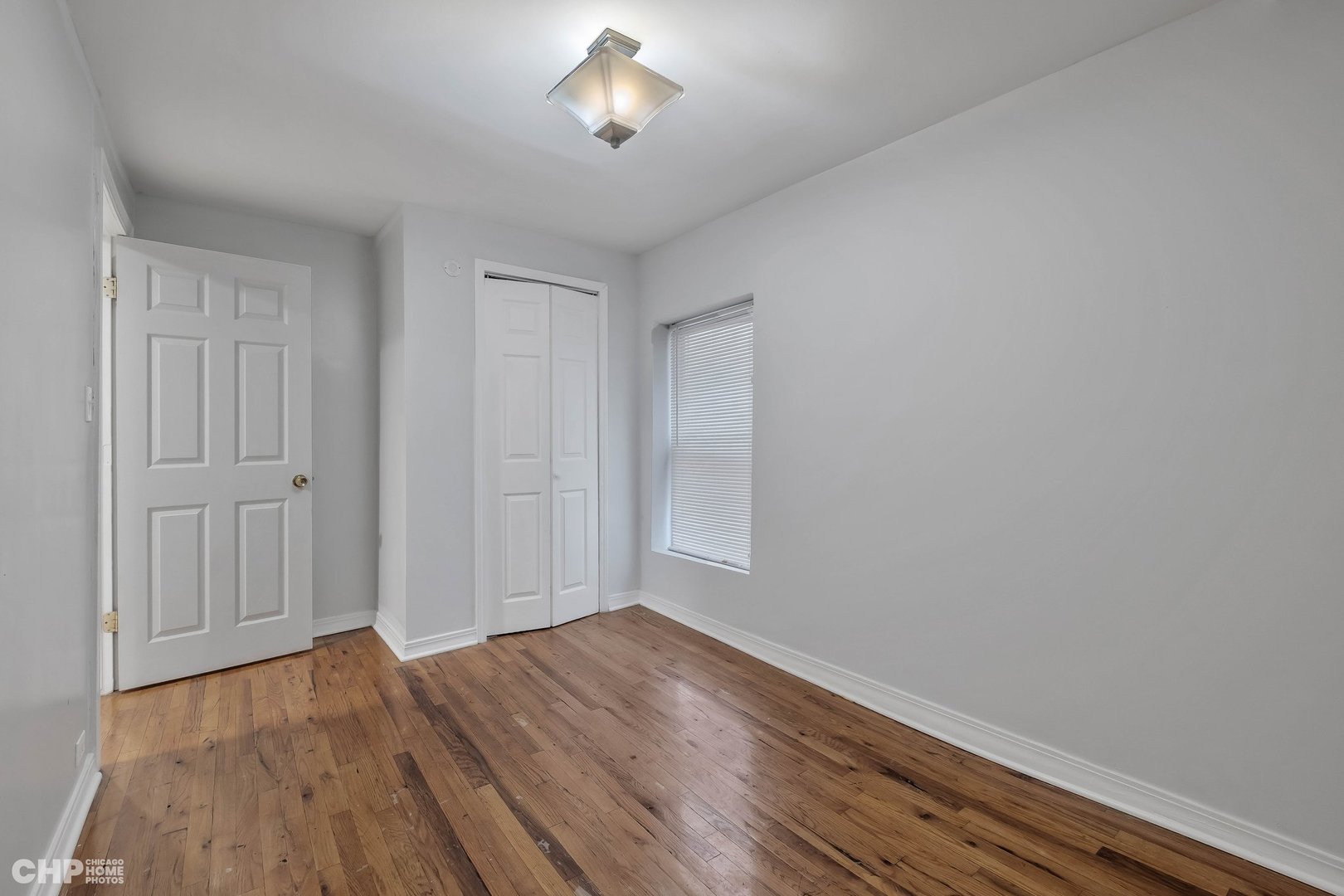 1052 North Springfield Avenue Chicago, IL 60651 - Photo 24 of 31 an empty room with wooden floor and windows