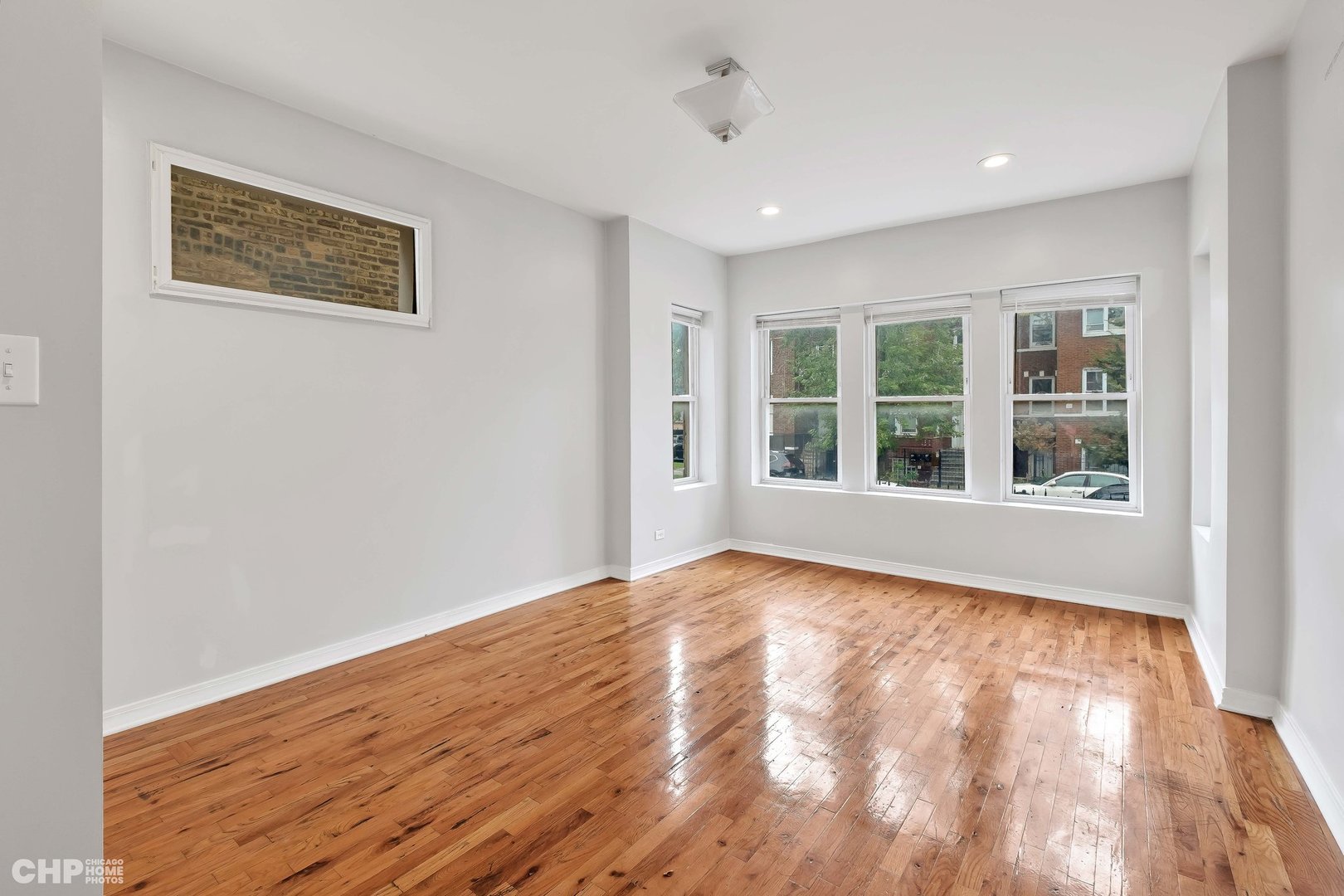 1052 North Springfield Avenue Chicago, IL 60651 - Photo 6 of 31 a view of an empty room with a window and wooden floor
