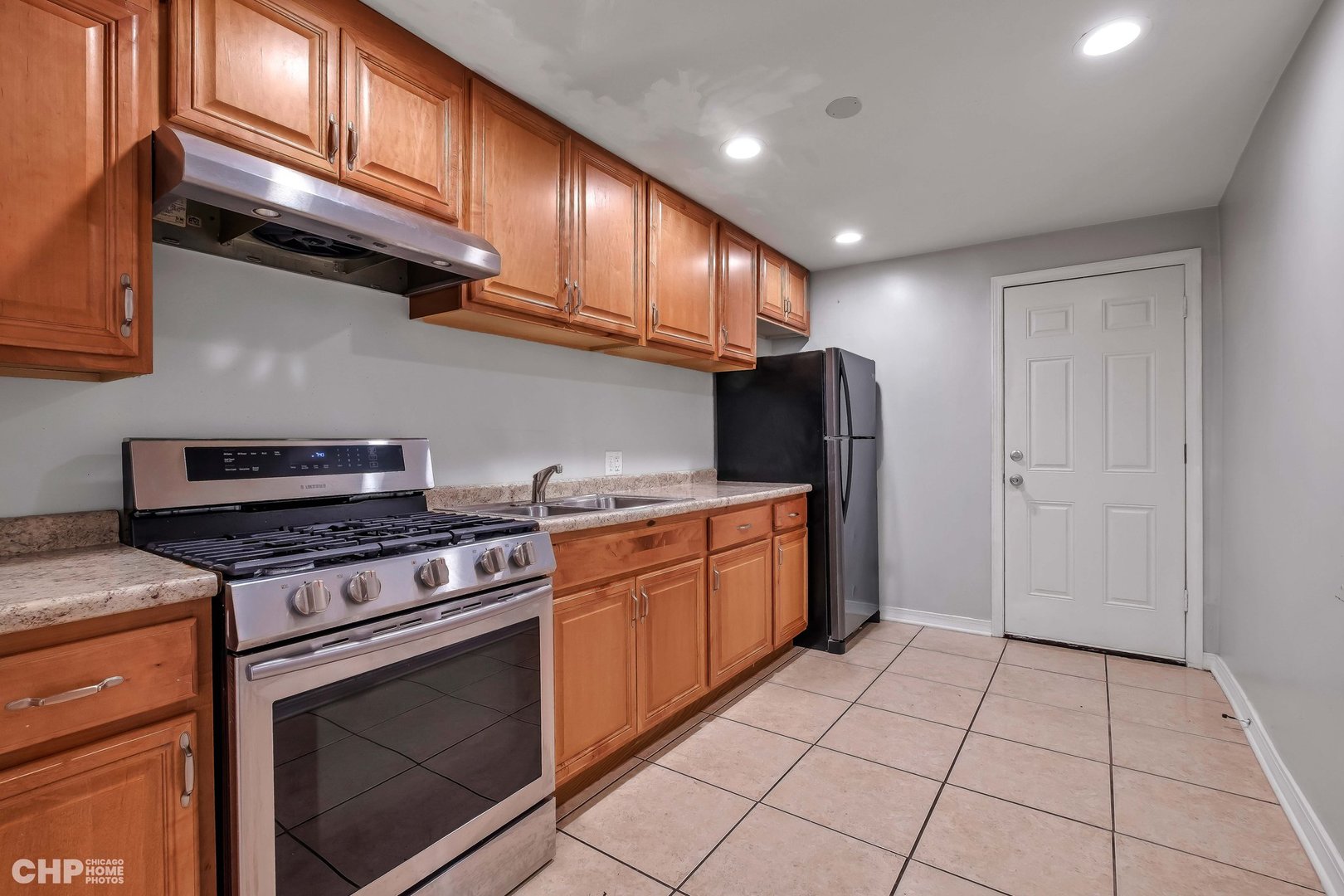 1052 North Springfield Avenue Chicago, IL 60651 - Photo 10 of 31 a kitchen with stainless steel appliances granite countertop a stove a refrigerator and a sink