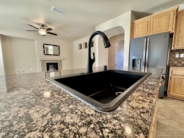 a view of a kitchen with a sink and refrigerator