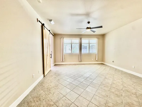 an empty room with closet and a ceiling fan