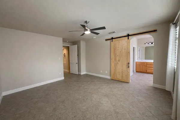 a living room with furniture and a refrigerator
