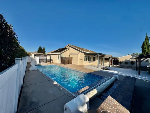 a view of a house with backyard and sitting area