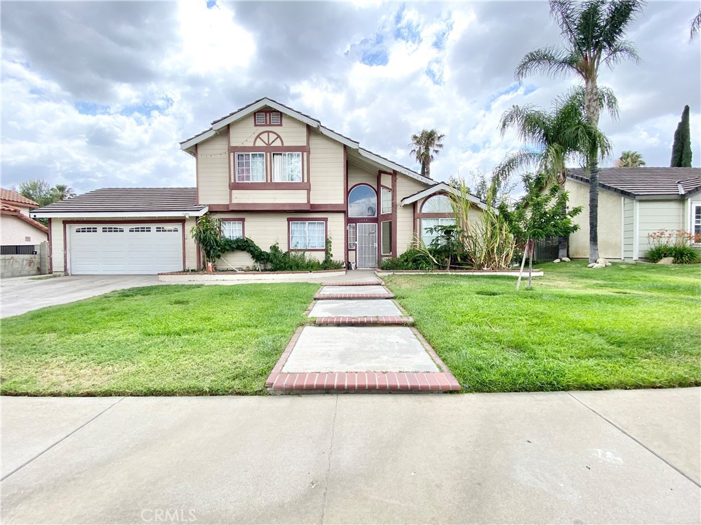 a front view of a house with a yard and potted plants