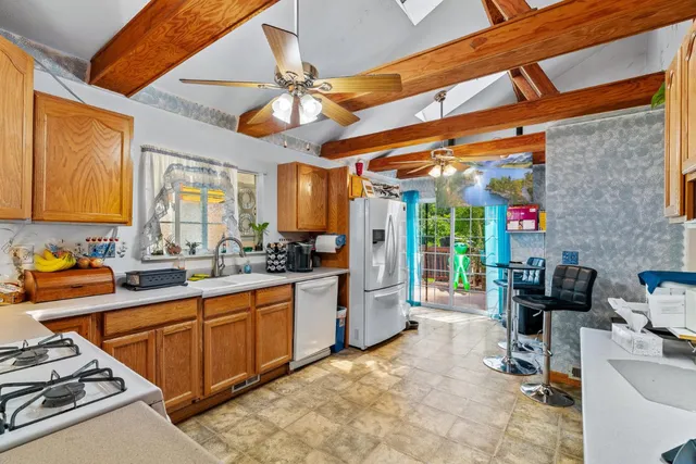 a kitchen with a sink cabinets stainless steel appliances and a window