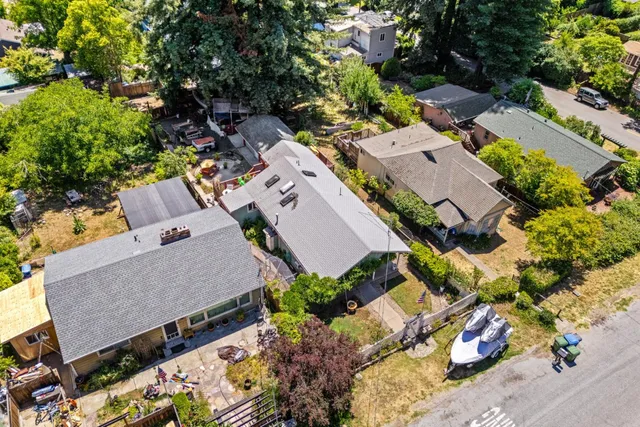 an aerial view of a house with a yard and ocean view